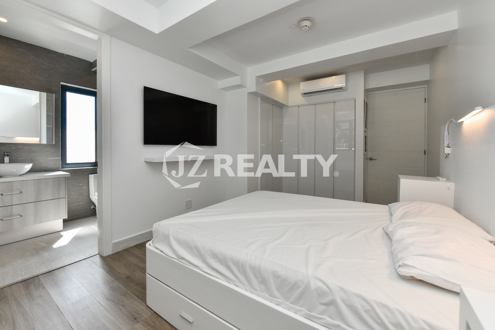 Master bedroom with TV and built-in closet at Coral Shell Condo 1H, Aruba.