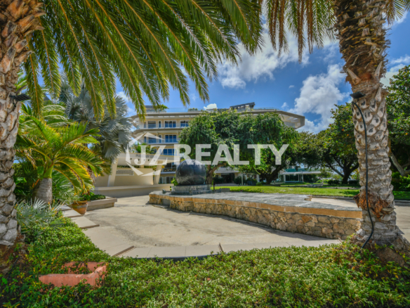 The lush entrance of Coral Shell Condo in Oranjestad, Aruba, featuring a tropical park-like setting.