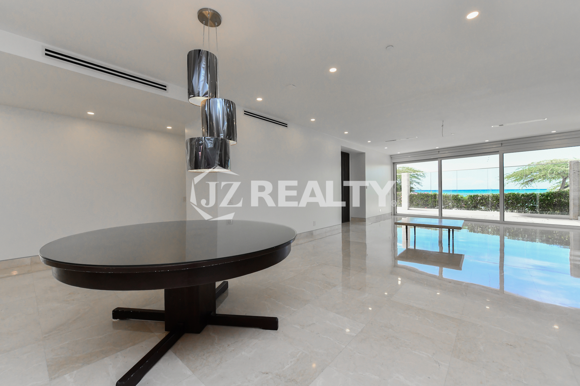 Elegant dining area with designer lighting and polished marble floors at Coral Shell Condo GF-C, Oranjestad, Aruba.