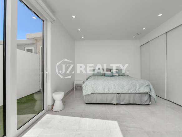 Floor-to-ceiling glass doors leading to a private oceanfront terrace at Coral Shell Condo GF-C, Oranjestad, Aruba.