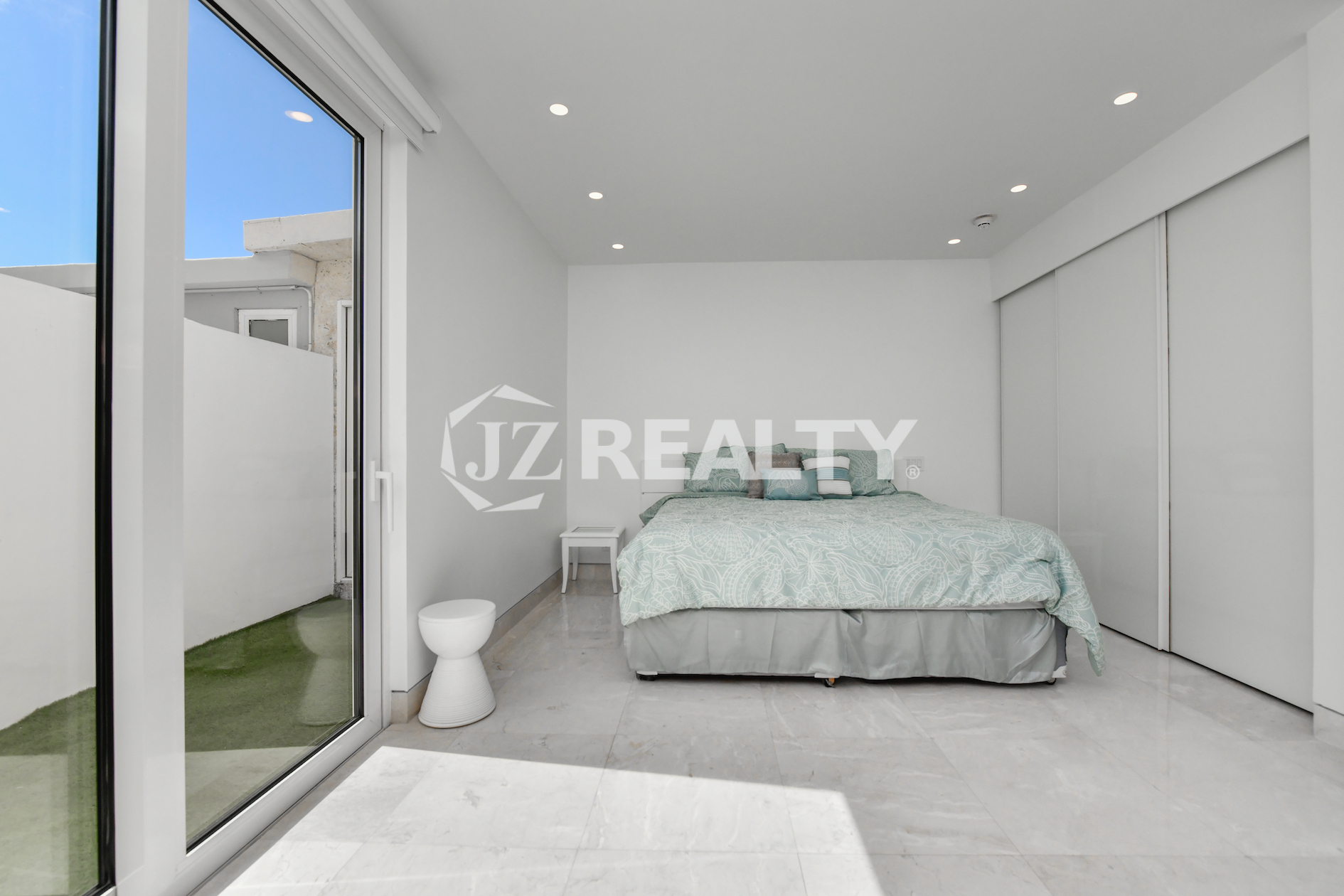 Floor-to-ceiling glass doors leading to a private oceanfront terrace at Coral Shell Condo GF-C, Oranjestad, Aruba.