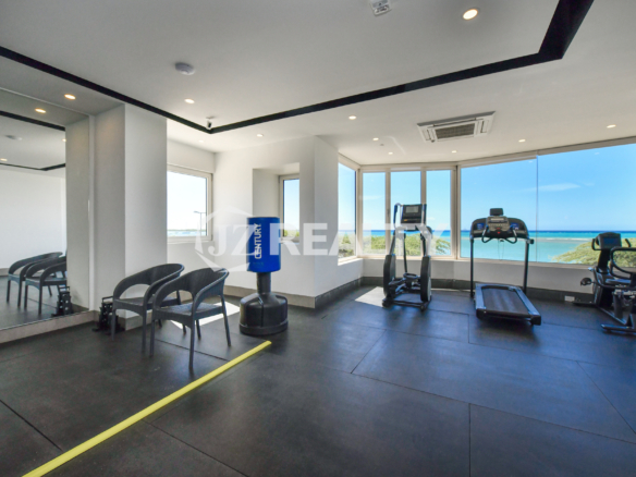 Fully equipped gym at Coral Shell Condo in Aruba, offering panoramic ocean views.