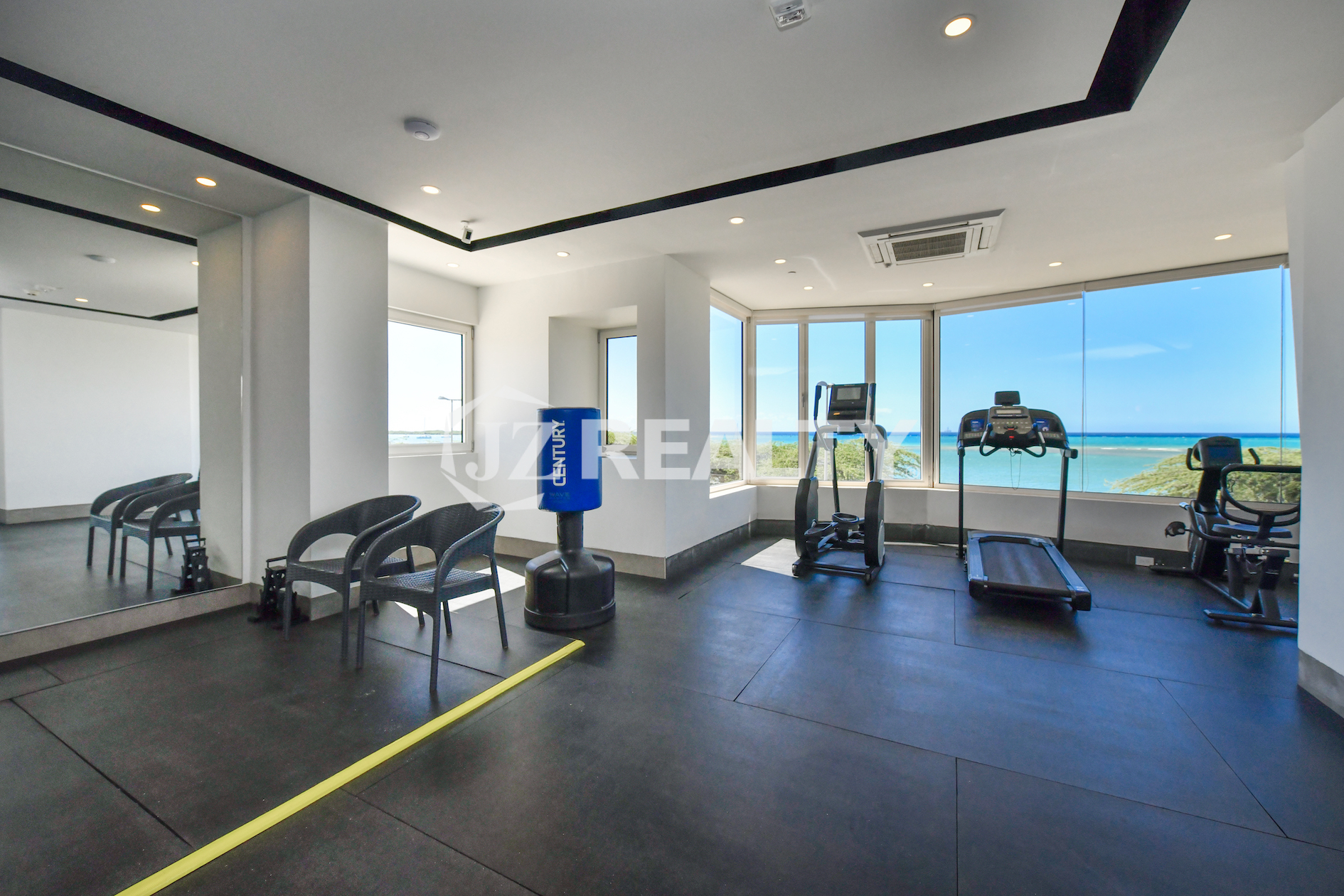 Fully equipped gym at Coral Shell Condo in Aruba, offering panoramic ocean views.