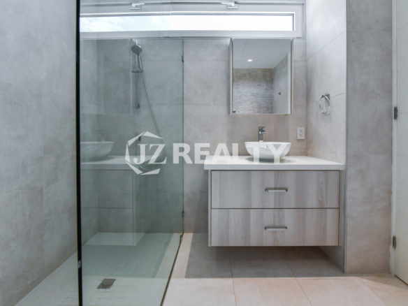 High-end master bathroom with glass-enclosed shower and elegant vanity at Coral Shell Condo GF-C, Oranjestad, Aruba.
