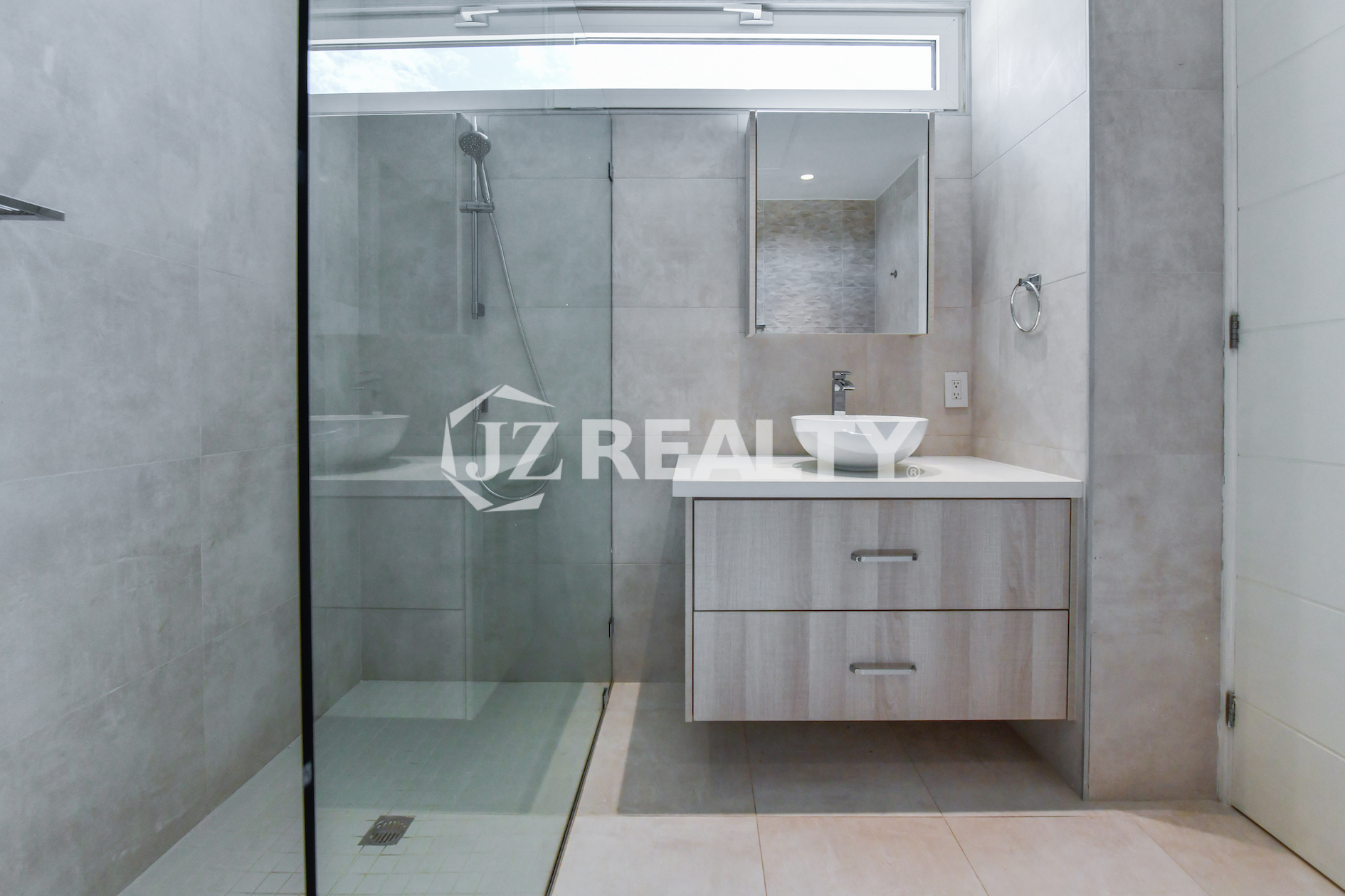 High-end master bathroom with glass-enclosed shower and elegant vanity at Coral Shell Condo GF-C, Oranjestad, Aruba.