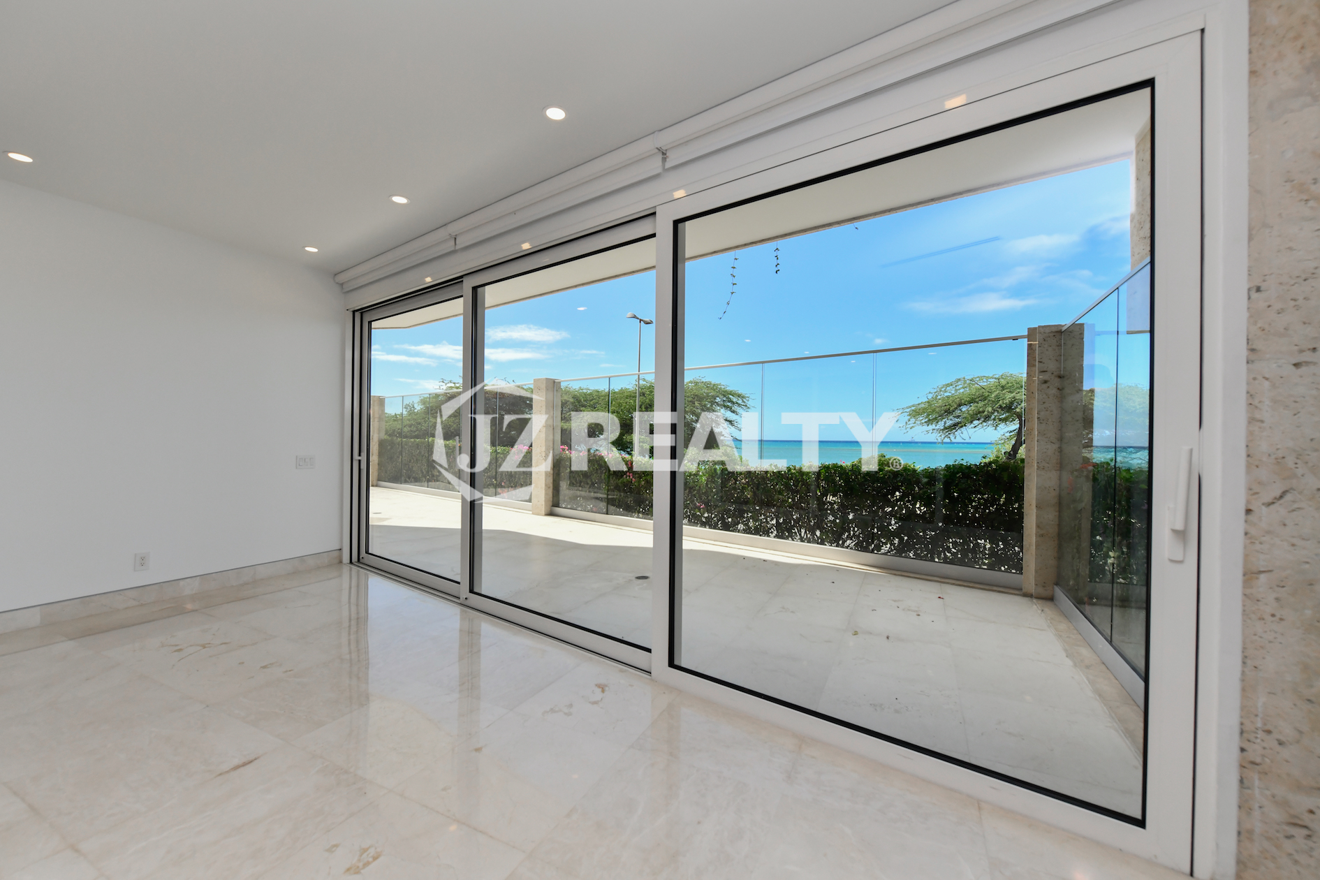 Modern master bedroom with private patio access at Coral Shell Condo GF-C in Oranjestad, Aruba.