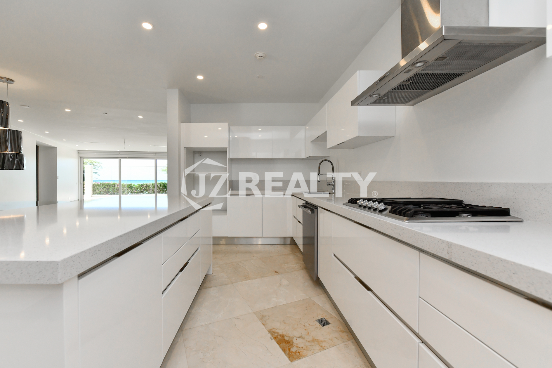 Spacious modern kitchen with white high-gloss cabinetry and ocean views at Coral Shell Condo in Oranjestad, Aruba.