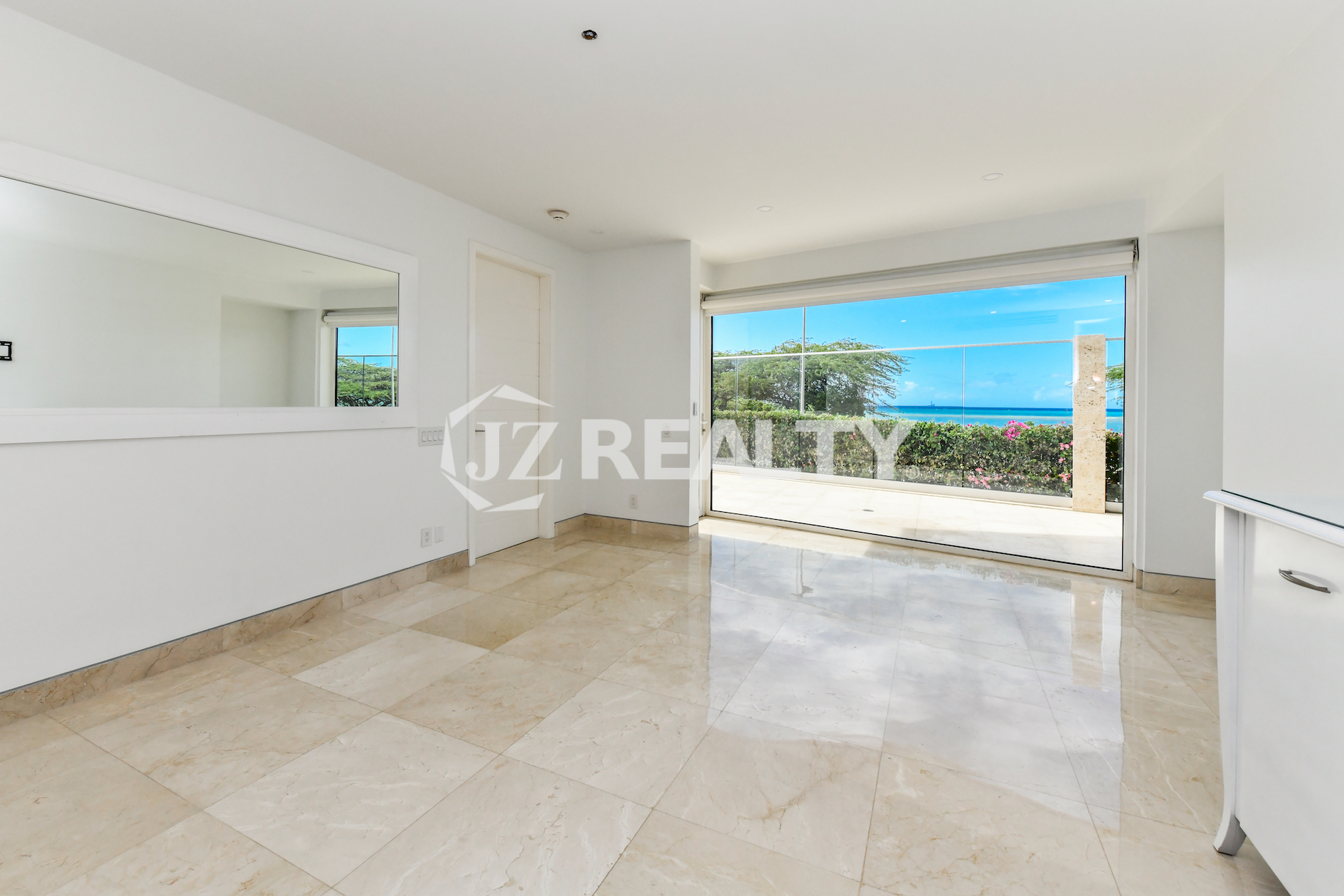 Spacious bedroom with an ocean view at Coral Shell Condo GF-C in Oranjestad, Aruba.