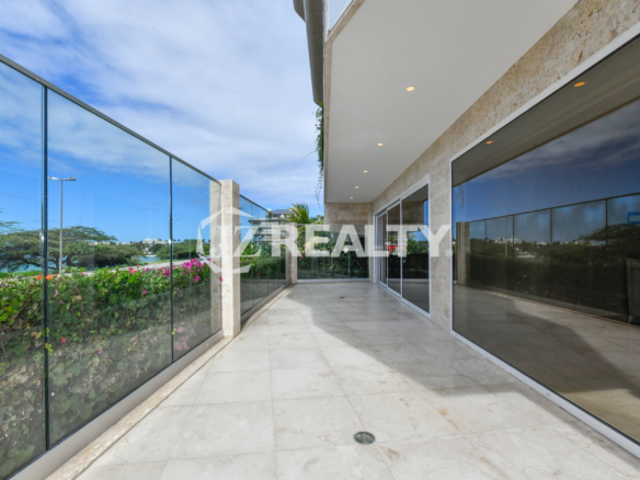 Private balcony with ocean views at Coral Shell Condo GF-C, featuring glass railings and marble flooring.