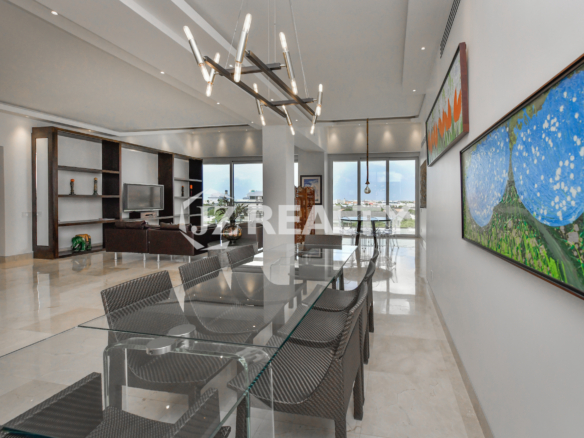 Glass dining table with modern decor and scenic views at Coral Shell Penthouse B, Aruba.