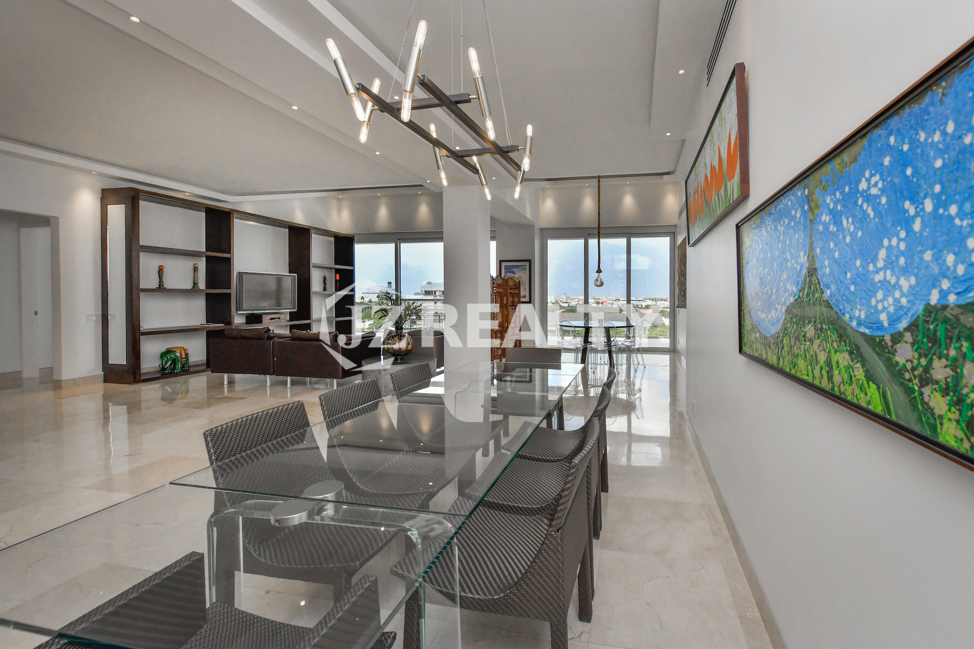 Glass dining table with modern decor and scenic views at Coral Shell Penthouse B, Aruba.