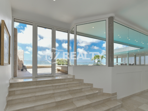 Stylish dining area at Coral Shell Penthouse B with panoramic ocean views and elegant decor.