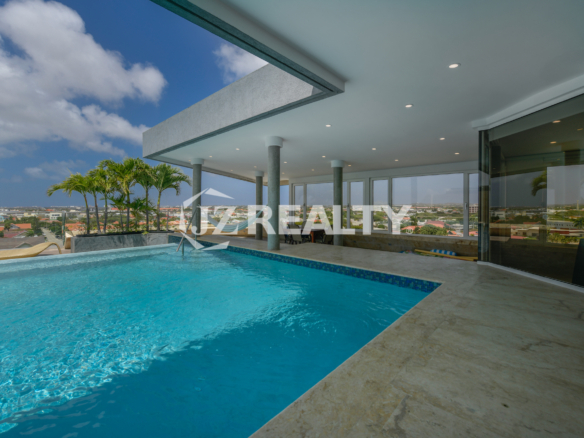 Infinity pool at Coral Shell Oceanfront Penthouse B with spectacular panoramic views of Aruba’s beaches and city skyline.