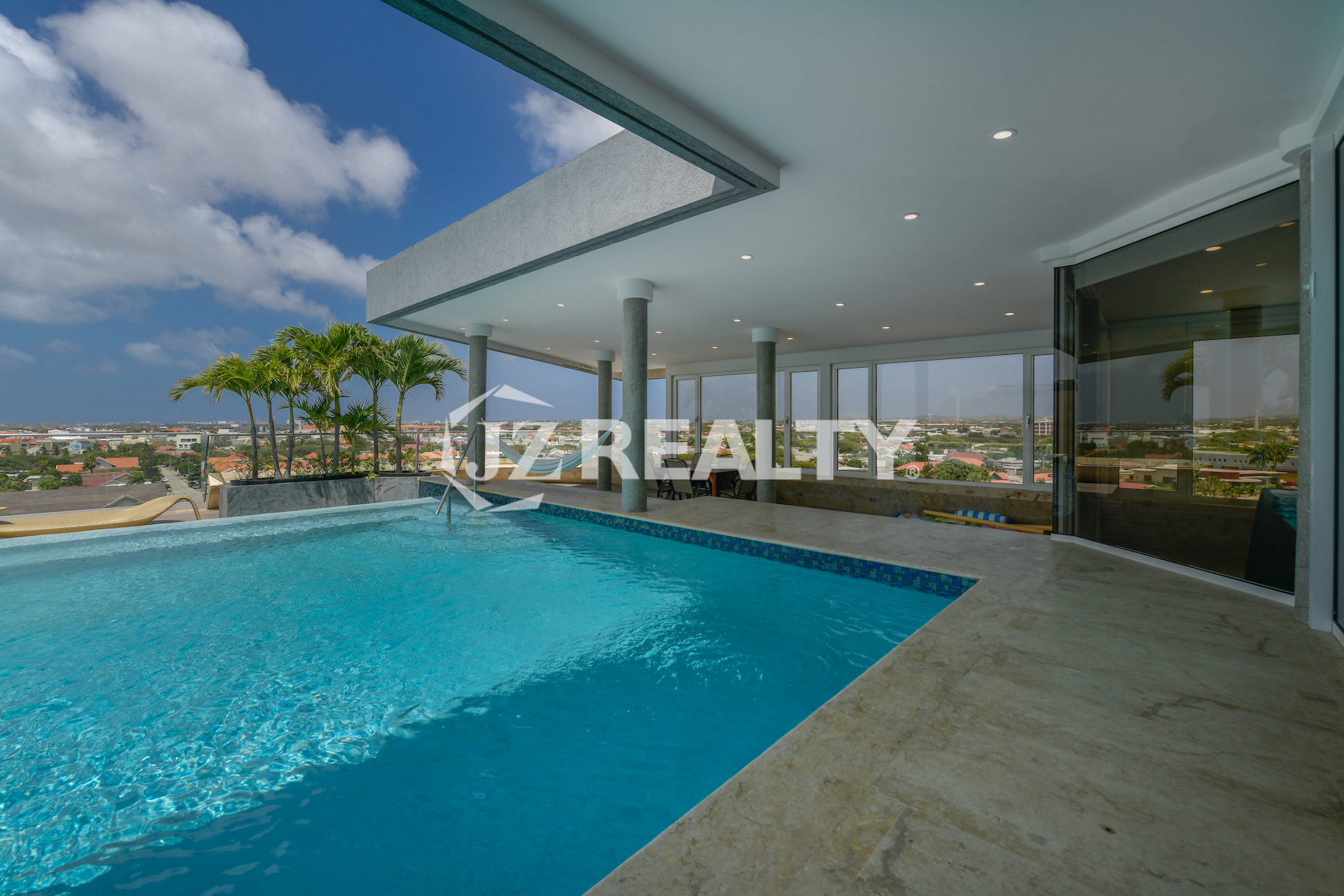 Infinity pool at Coral Shell Oceanfront Penthouse B with spectacular panoramic views of Aruba’s beaches and city skyline.