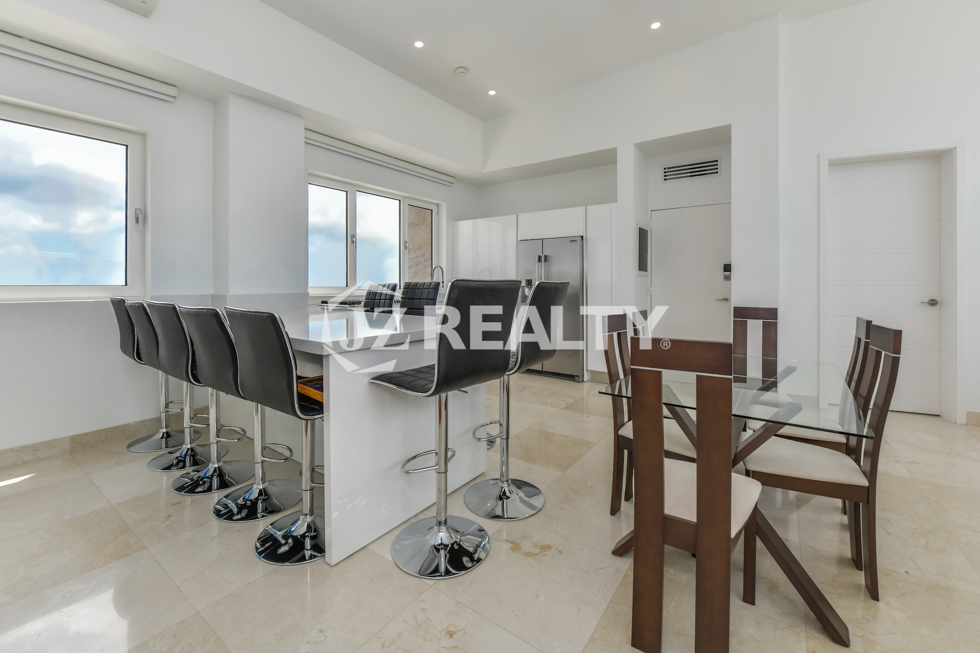 Luxurious kitchen with ocean view at Coral Shell Penthouse B, featuring modern appliances and elegant white design.
