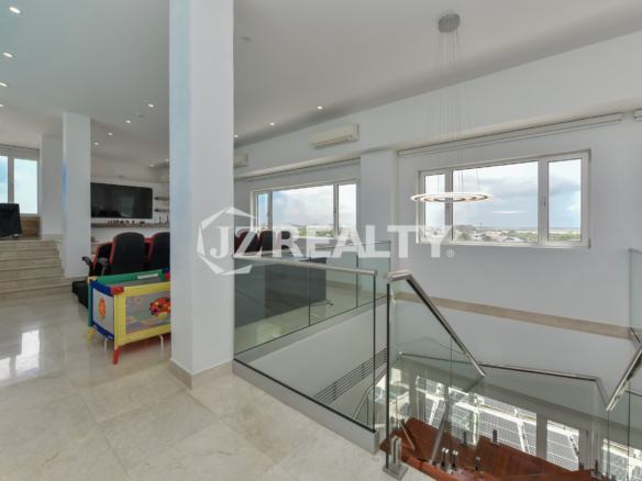 Spacious living room with elegant furnishings and panoramic city views at Coral Shell Penthouse B.