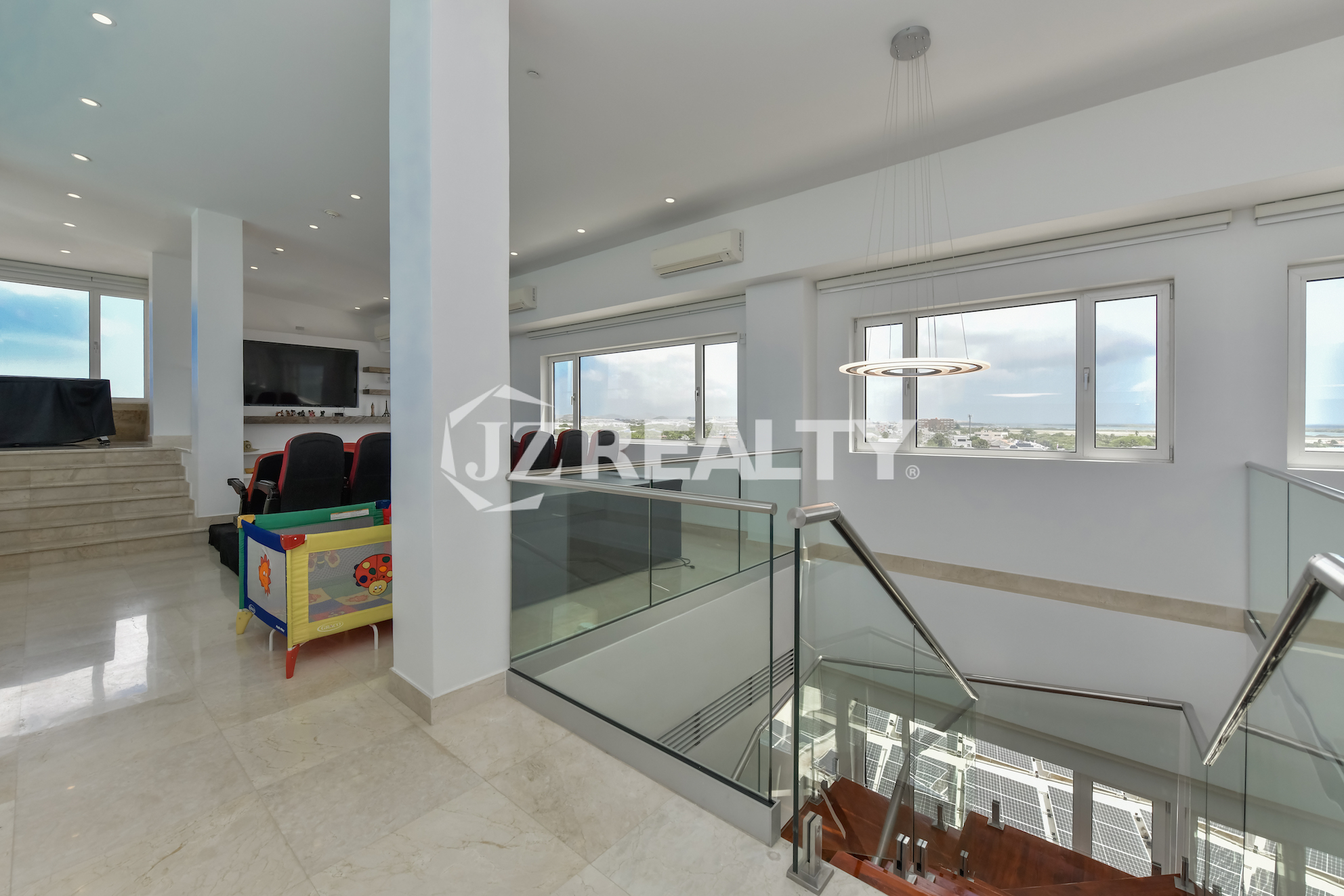 Spacious living room with elegant furnishings and panoramic city views at Coral Shell Penthouse B.