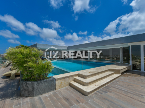 Rooftop infinity pool at Coral Shell Oceanfront Penthouse B in Aruba, offering breathtaking panoramic ocean and island views.