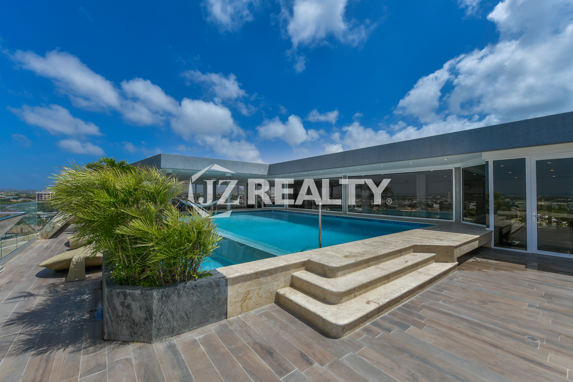 Rooftop infinity pool at Coral Shell Oceanfront Penthouse B in Aruba, offering breathtaking panoramic ocean and island views.