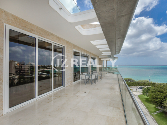 Bright and airy master bedroom in Coral Shell Penthouse B featuring a king-sized bed, large windows, and spectacular ocean views.