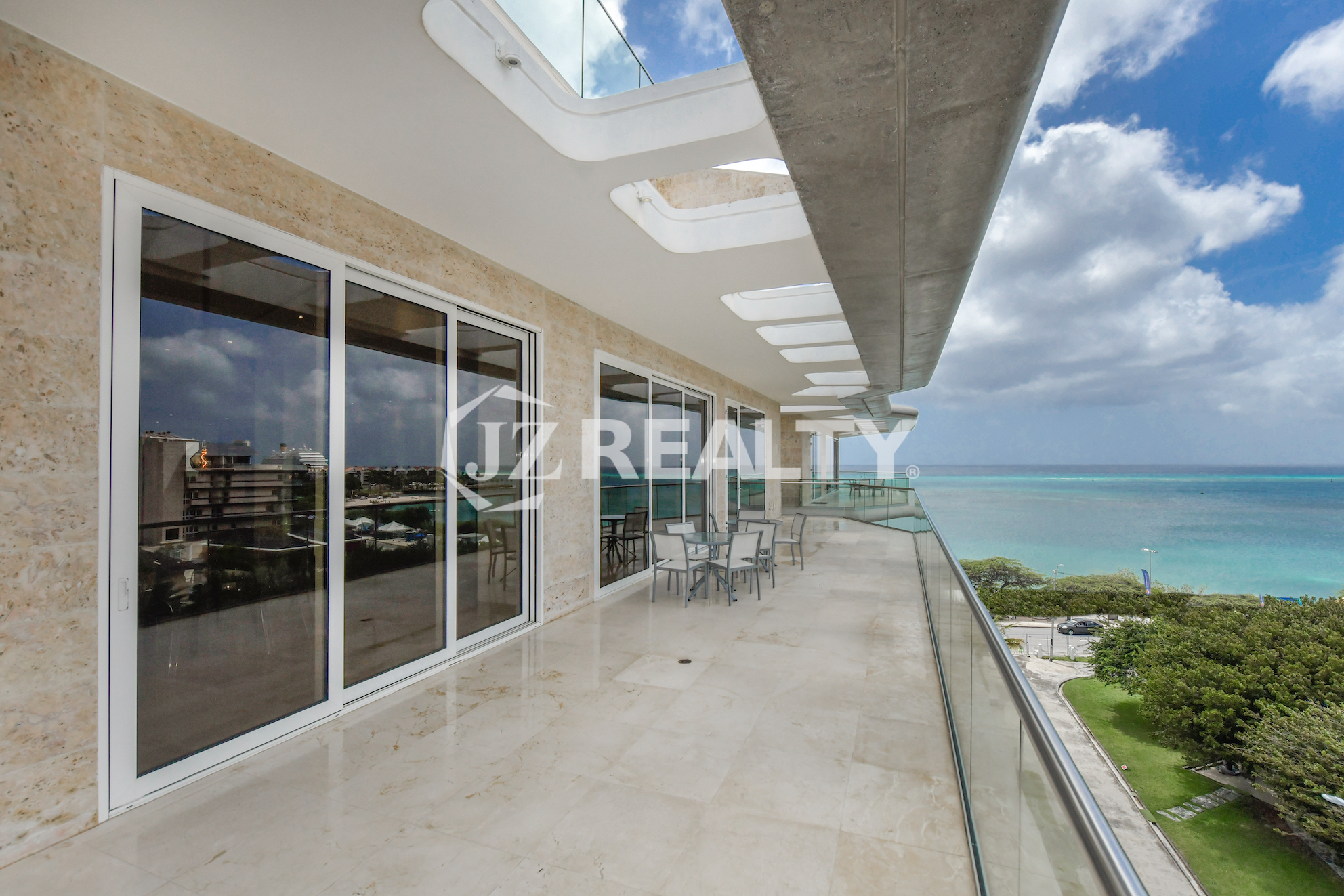 Bright and airy master bedroom in Coral Shell Penthouse B featuring a king-sized bed, large windows, and spectacular ocean views.