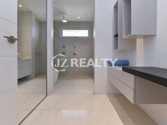 Stylish dressing area in Coral Shell Penthouse B featuring sleek built-in storage, a vanity counter, and marble flooring.
