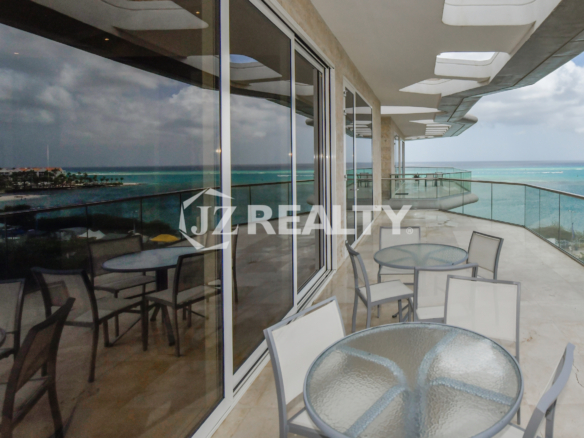 Spectacular oceanfront balcony at Coral Shell Penthouse B, offering ample seating, glass railings, and uninterrupted sea views.