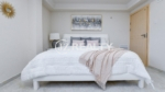 condo 316 second bedroom with white platform bed and artwork