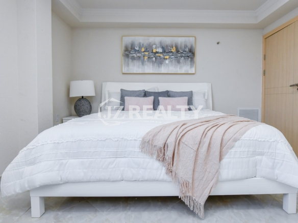 condo 316 second bedroom with white platform bed and artwork