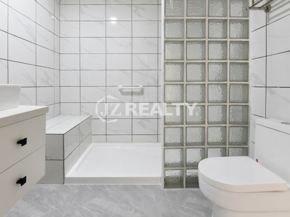 condo 215 bathroom with tub shower combination and glass blocks