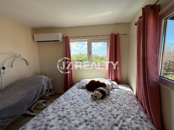Bright guest bedroom with three windows, pink curtains, and nature views at Alto Vista 26-W Apartment 8.