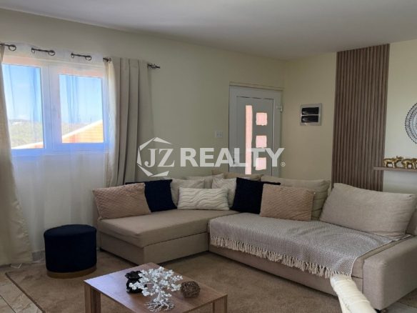 Living room with L-shaped sectional sofa and large window.