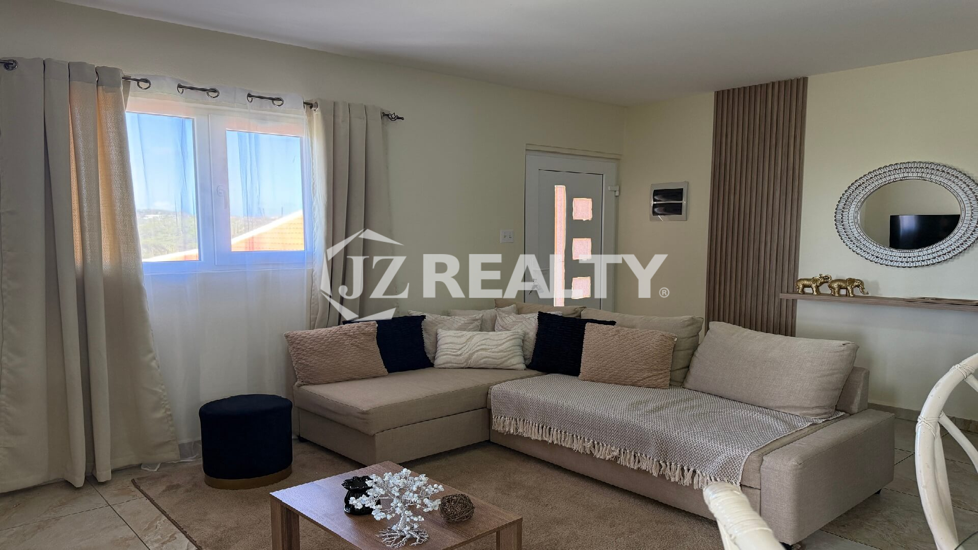 Living room with L-shaped sectional sofa and large window.