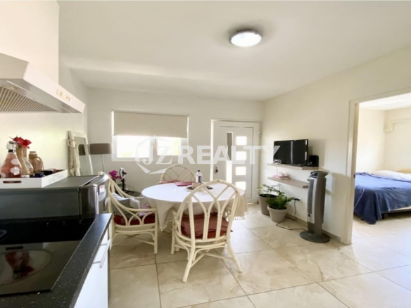 Open-concept living and dining area showing entry door and bedroom doorway.