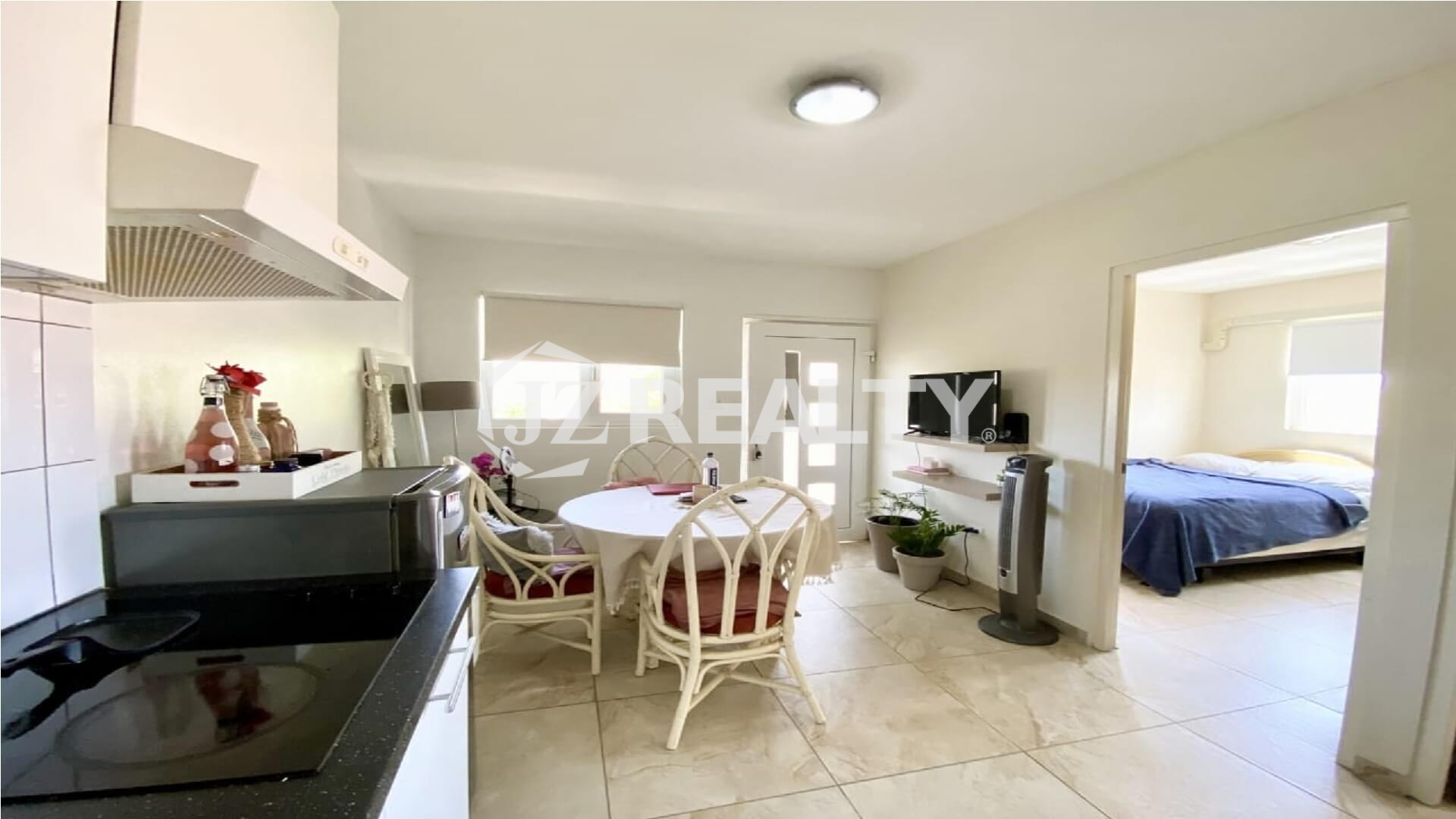 Open-concept living and dining area showing entry door and bedroom doorway.