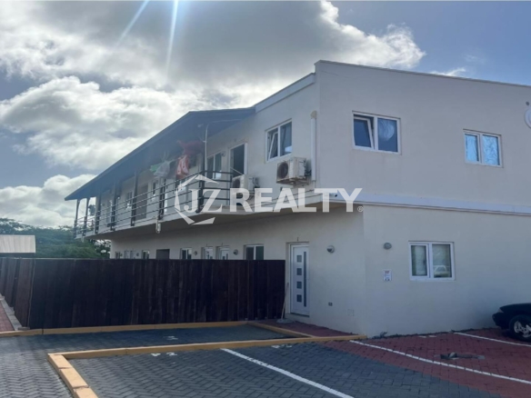 Exterior view of a modern two-story apartment complex under blue sky.