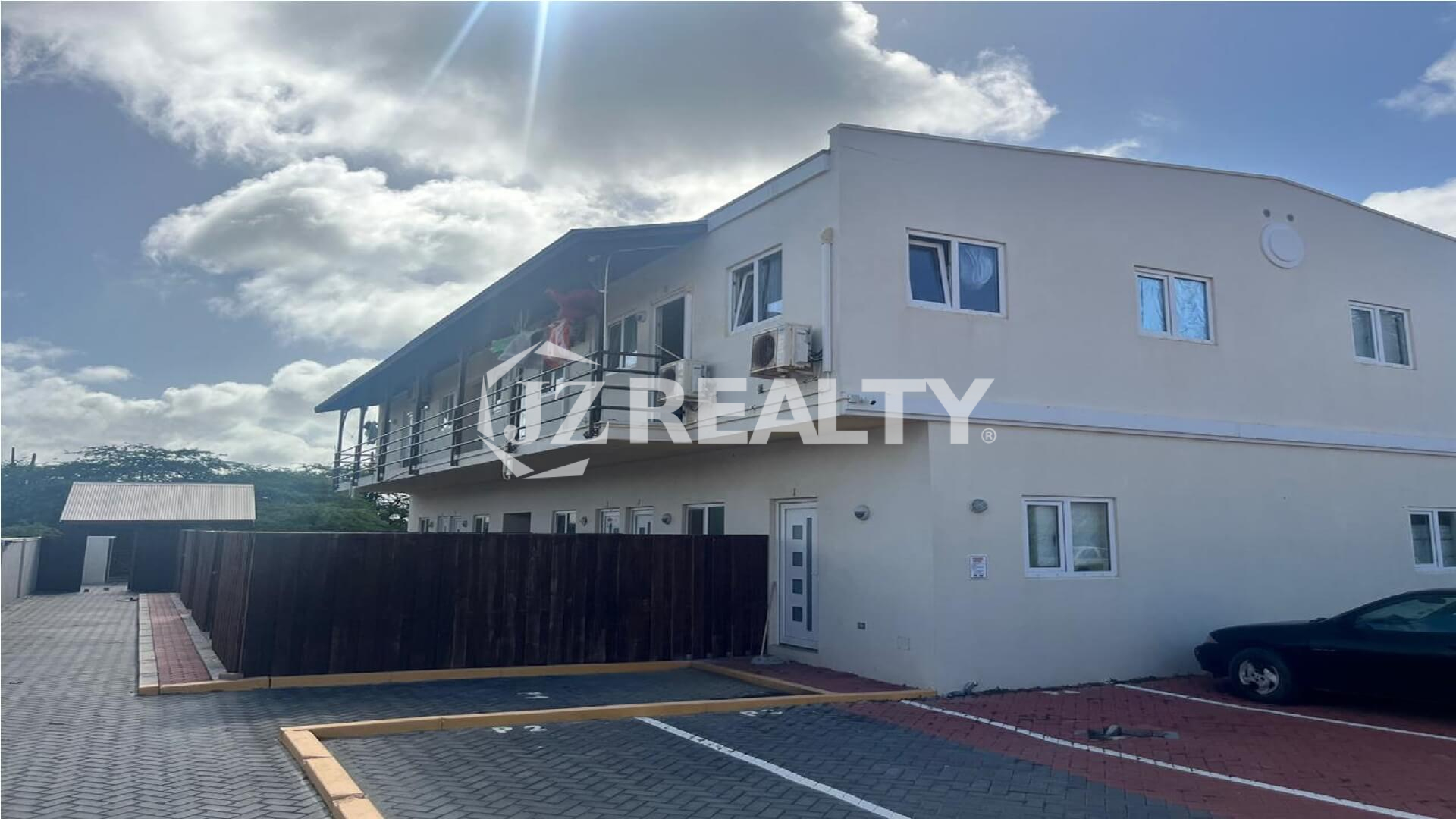 Exterior view of a modern two-story apartment complex under blue sky.