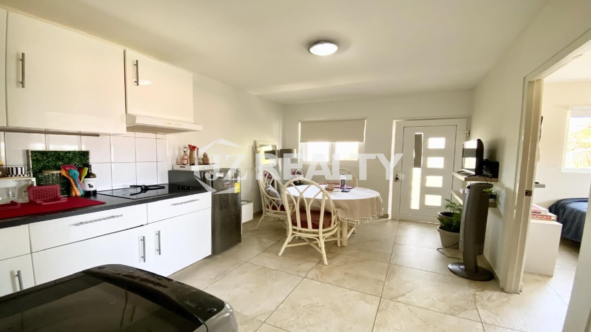 Open kitchen and dining area with round table, chairs and window light.