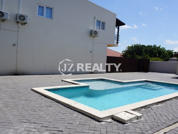Small rectangular outdoor swimming pool set in a paved courtyard.