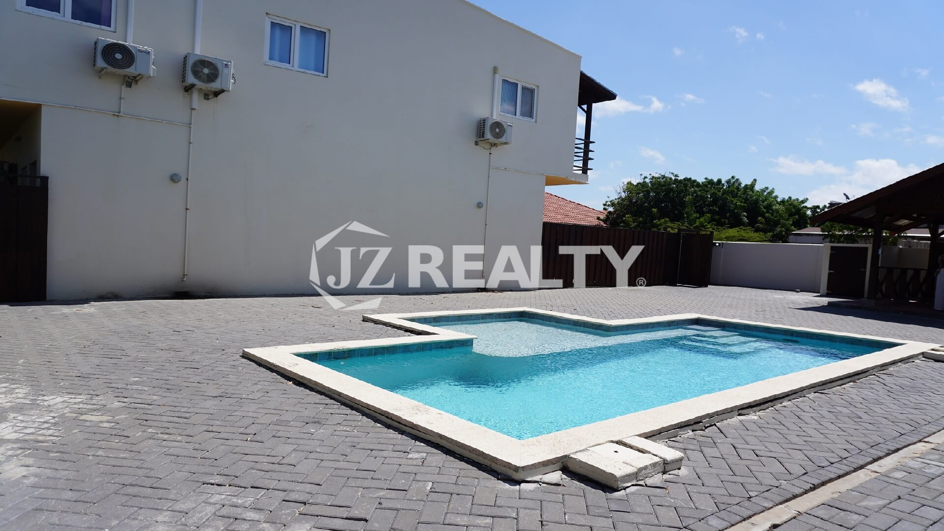 Small rectangular outdoor swimming pool set in a paved courtyard.