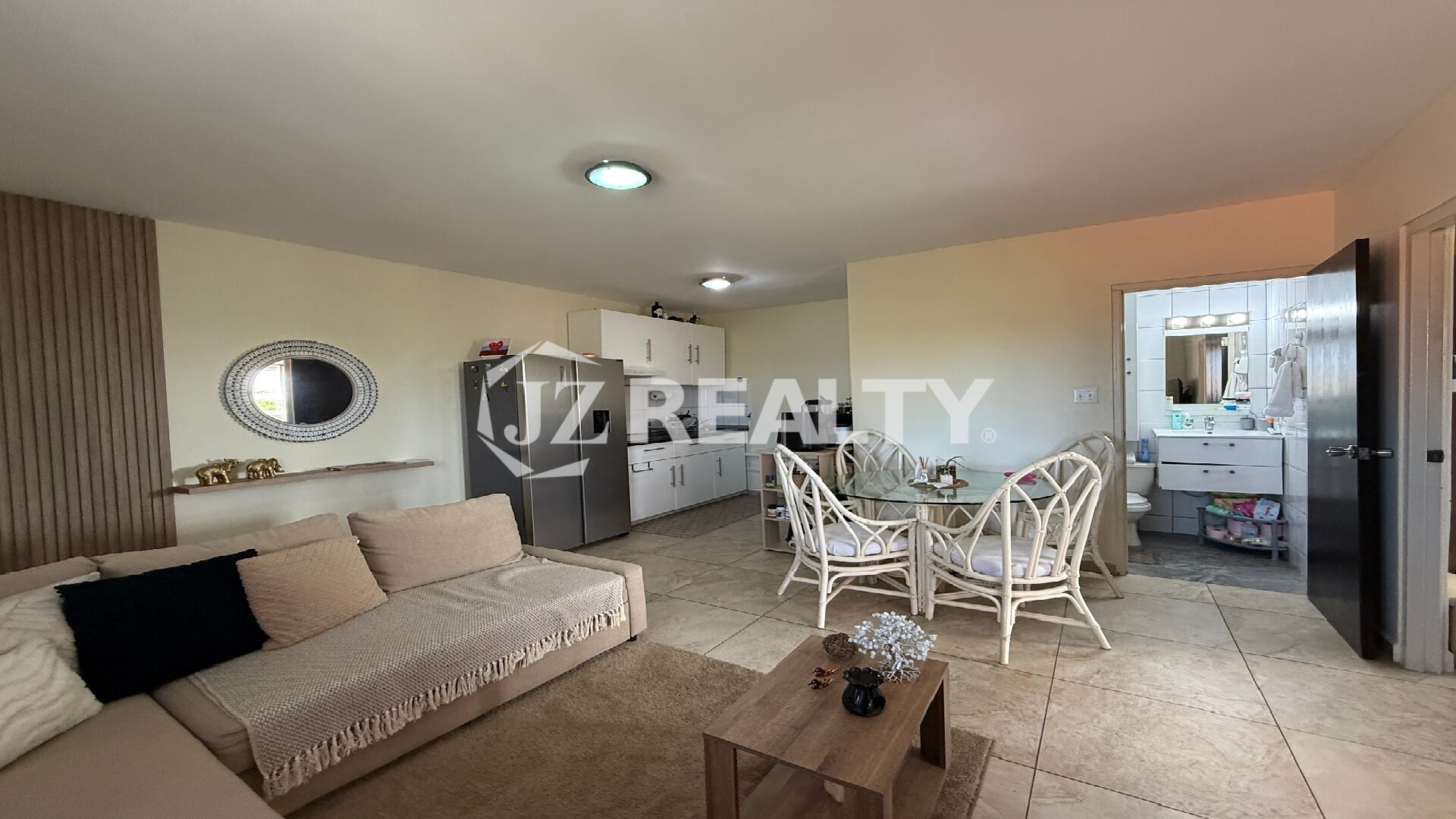 View of kitchen, dining table, and sofa area in an open-concept layout.