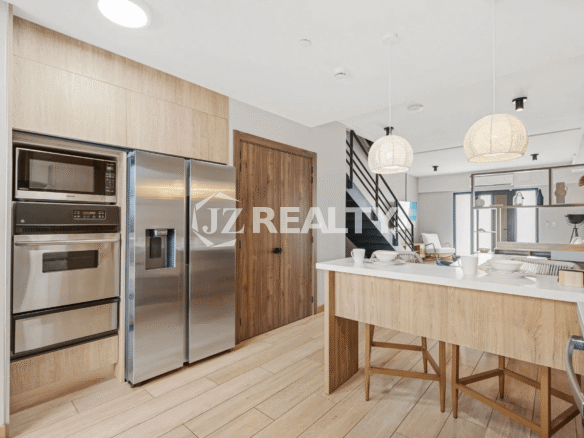 View of the stainless steel refrigerator, built-in microwave, and oven within the modern kitchen of Porta al Sole Unit 10.