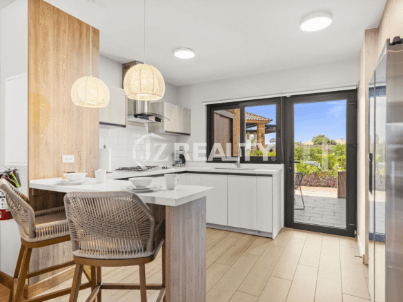 Bright, modern kitchen in Porta al Sole Unit 10 with white countertops, rattan pendant lights, and breakfast bar seating.