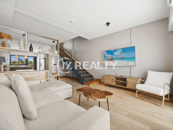 Wide view of the contemporary living room in Porta al Sole Unit 10 with a large sectional sofa, wood coffee table, and an open staircase.