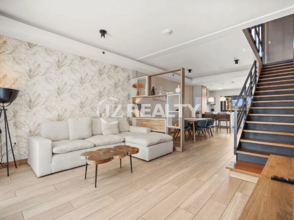 The open-plan main level of Porta al Sole Unit 10, showing the seamless flow between the living room with accent wallpaper and the dining area.