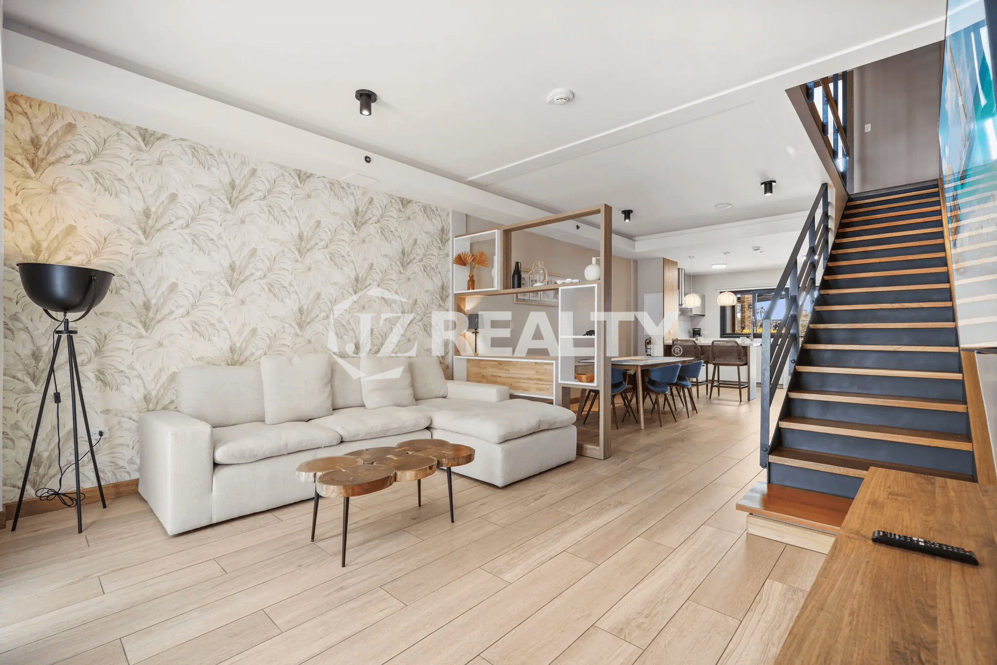 The open-plan main level of Porta al Sole Unit 10, showing the seamless flow between the living room with accent wallpaper and the dining area.