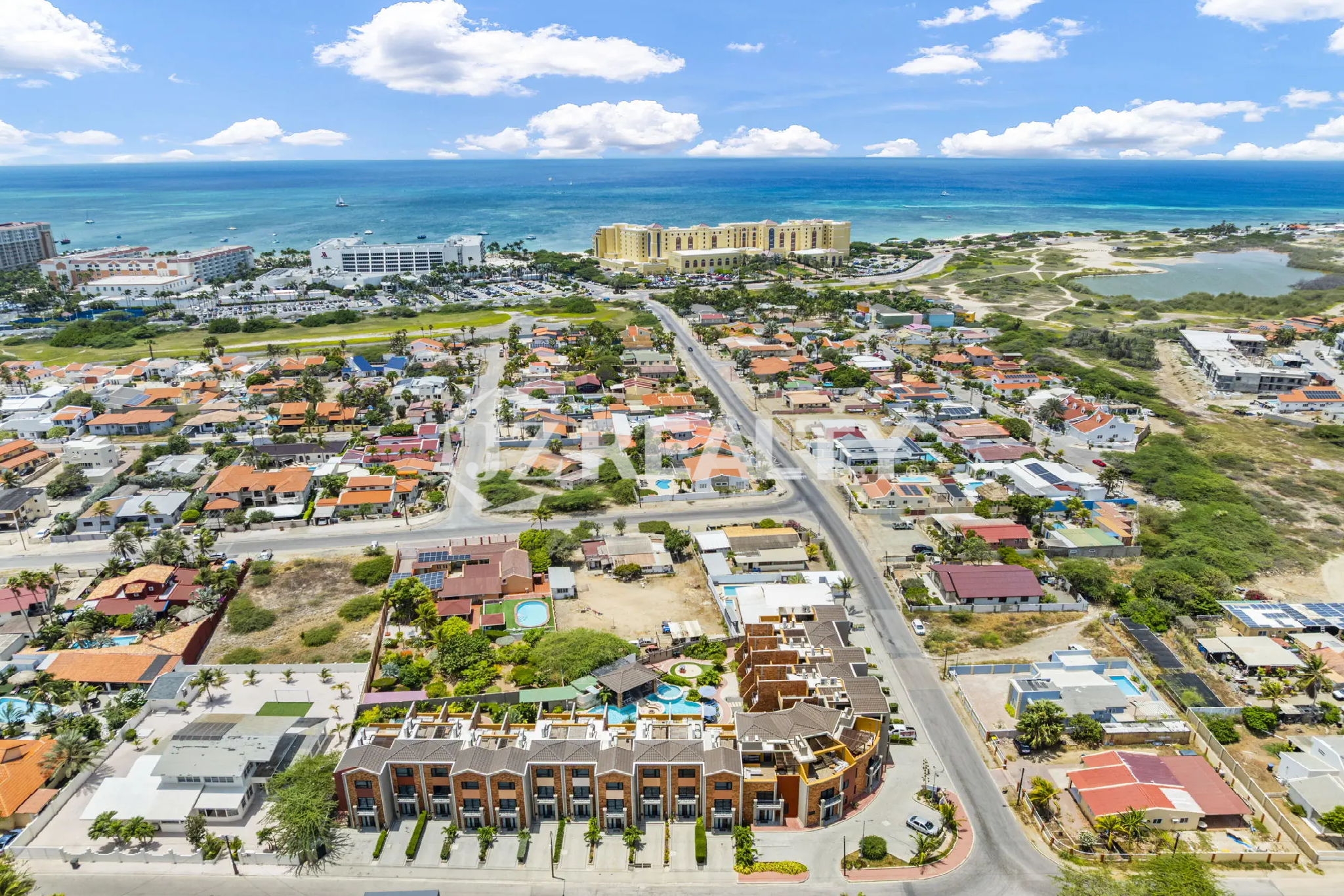Porta al Sole Unit 11 wide aerial view of the community and surrounding neighborhood, showing the proximity to the ocean and major resort buildings.