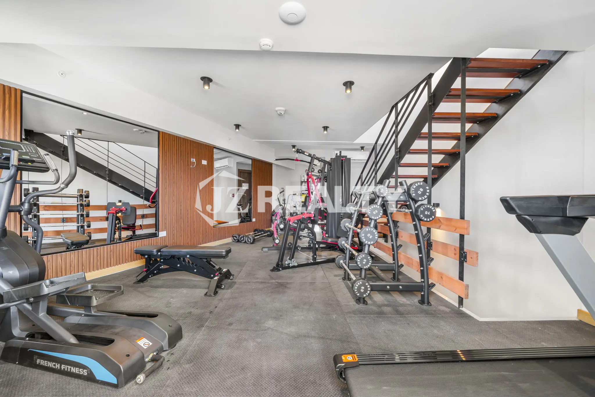Porta al Sole Unit 11 on-site fitness center with various exercise equipment including treadmills, weight racks, and a workout bench.