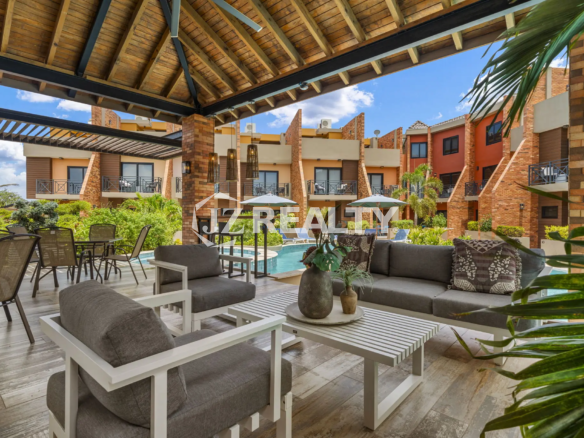 Porta al Sole Unit 11 covered poolside gazebo lounge with comfortable outdoor sofas, armchairs, coffee tables, and view of the surrounding resort units.