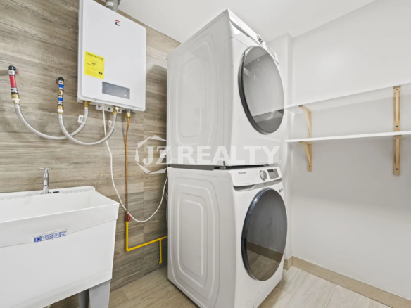 Porta al Sole Unit 11 modern laundry room with stacked washer and dryer, white utility sink, and wall-mounted tankless water heater.